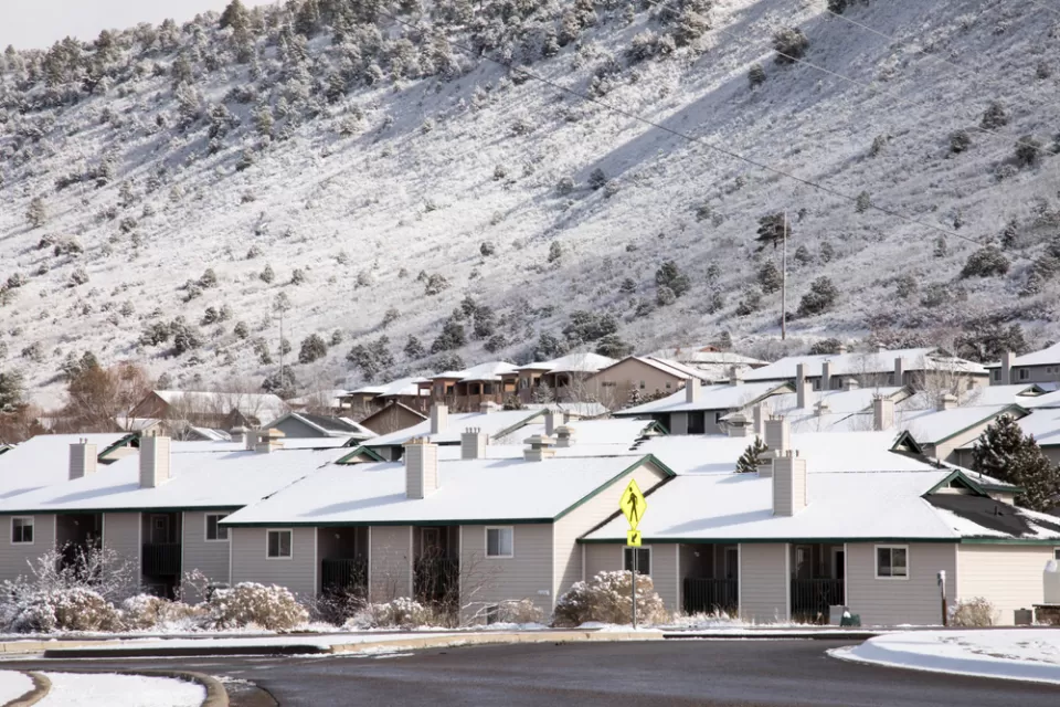 One-story houses dusted with snow in Durango, Colorado with snowy mountainside in background